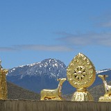 Deers and Dharma  The two deers and the wheel of Dharma are a symbol towering the entrance of each buddhis temple. Here in Ganden Sumtseling Gompa, backed by the Shika Snow Mountain.